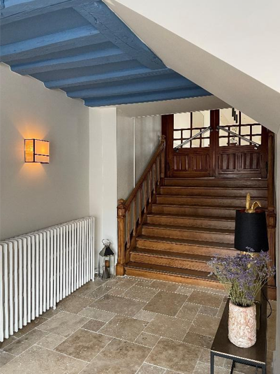 Entrée rénovée avec escalier en bois et sol en pierre