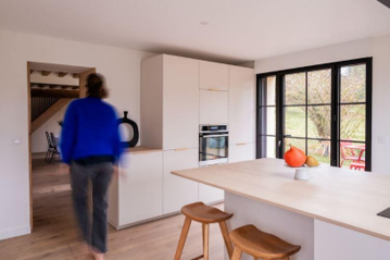 Cuisine lumineuse avec îlot central et verrière noire